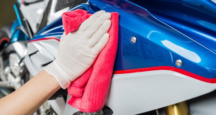 person polishing a motorcycle after painting