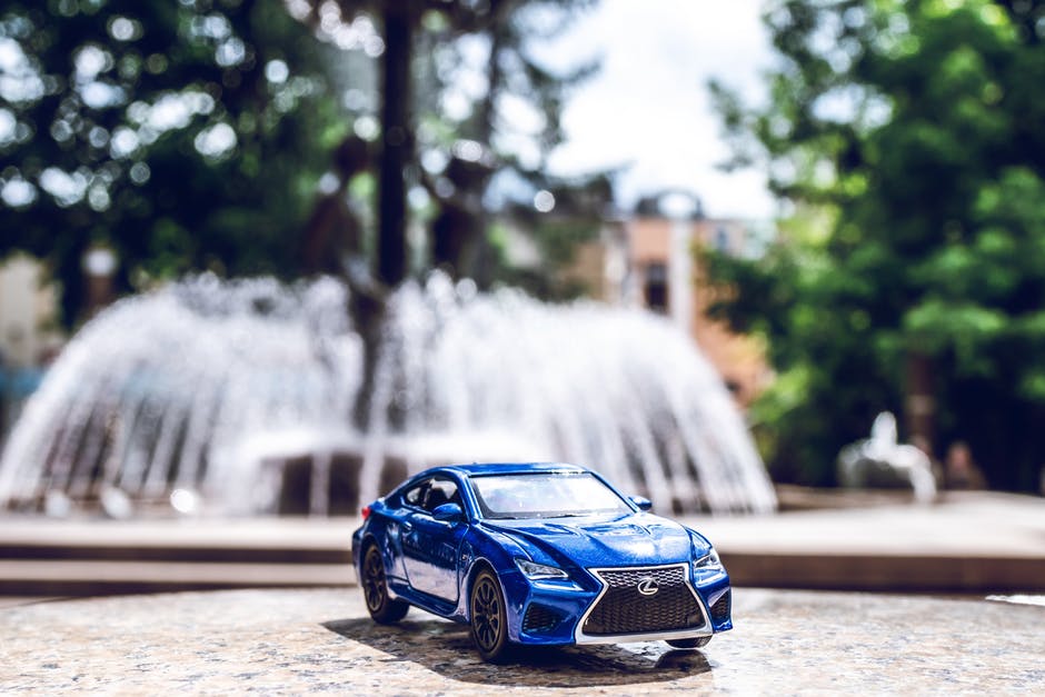 blue car with fountain in background