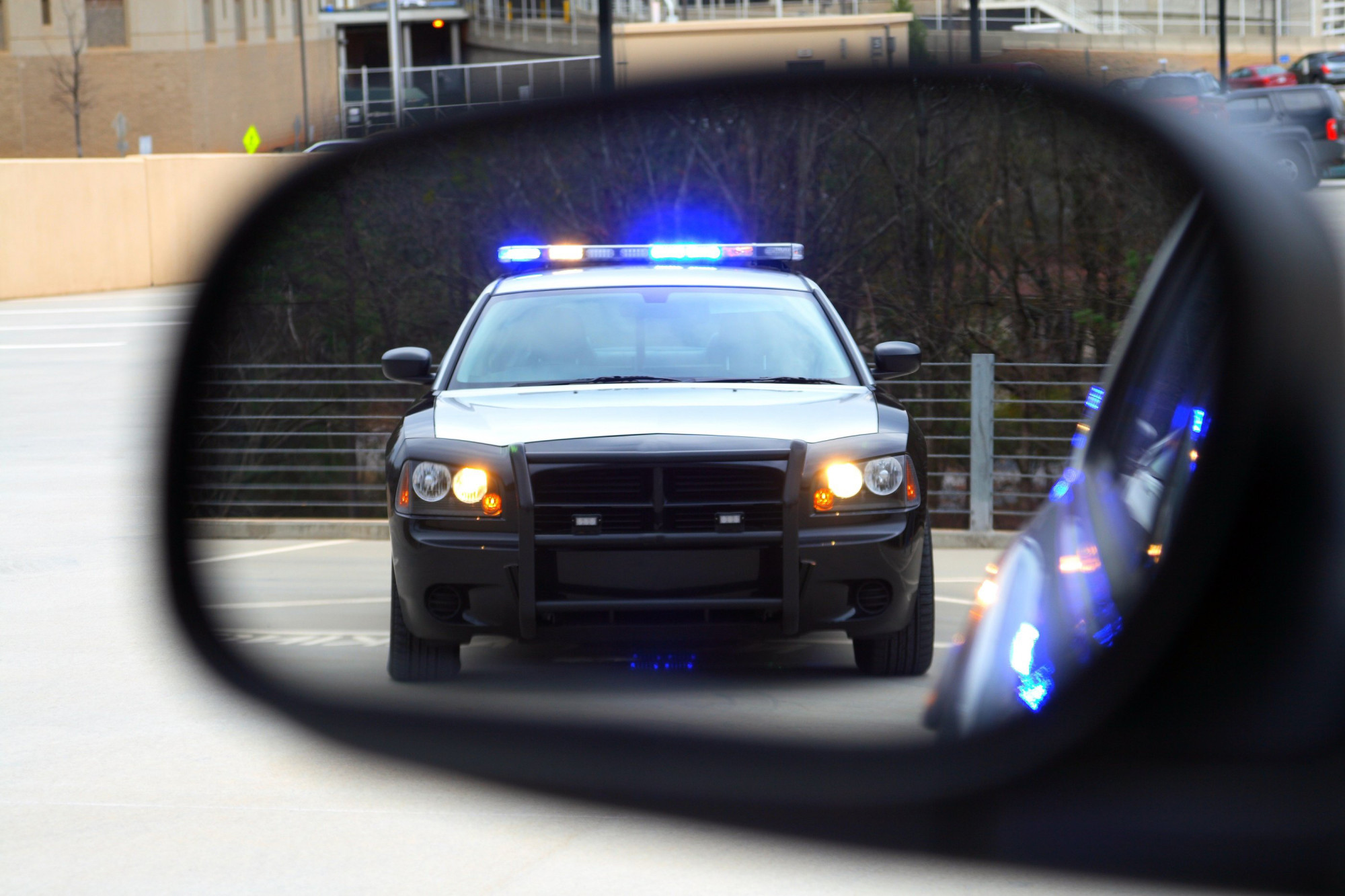 cop pulling over car in side mirror