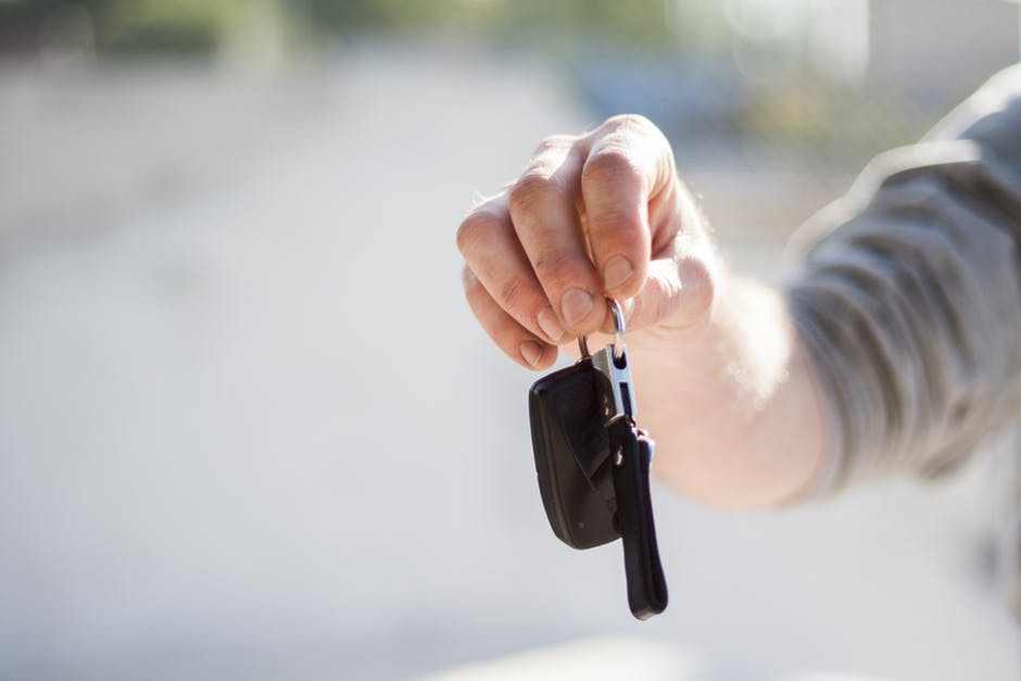 person holding keys to sell a car