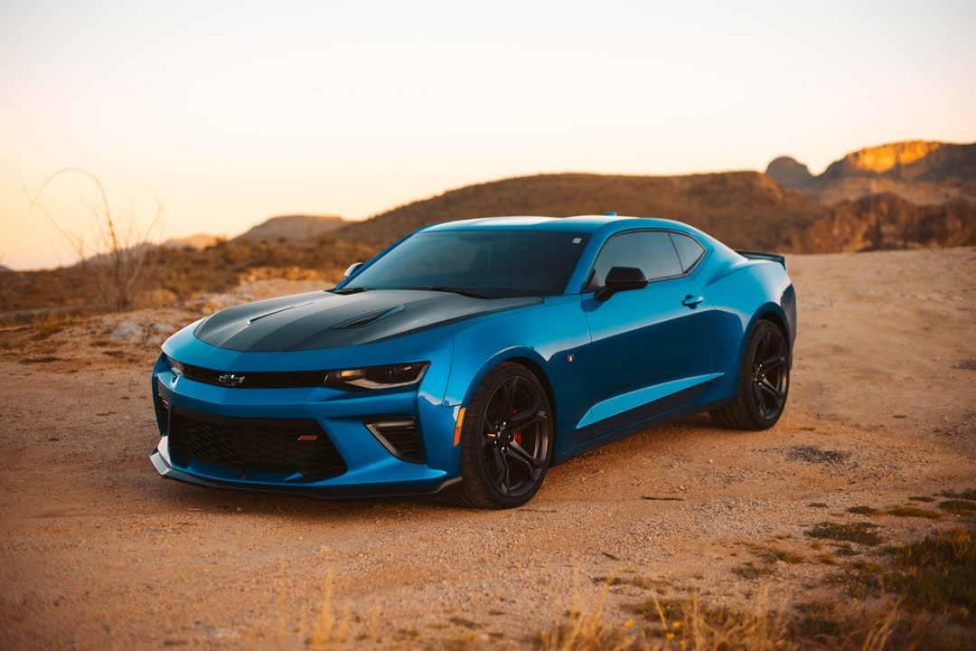 blue Chevrolet on dirt road