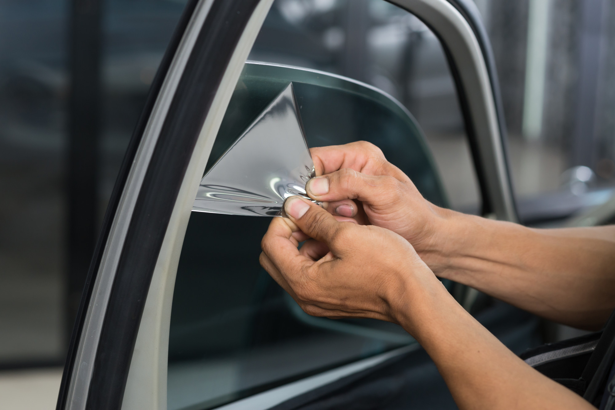 person tinting car window