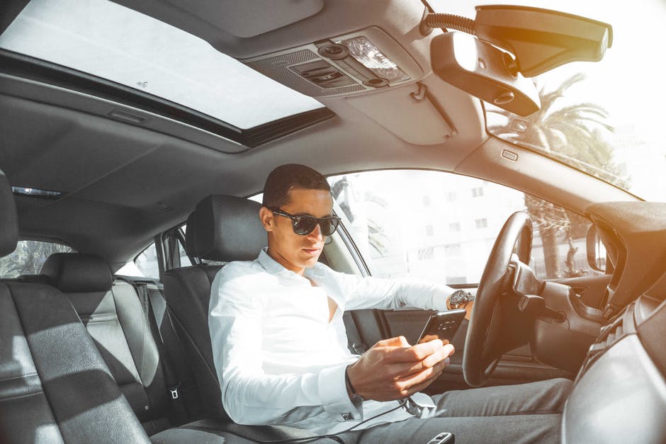 Man Using Smartphone on His Car